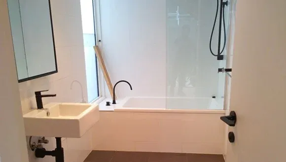 Clean white bathroom with a bath and shower