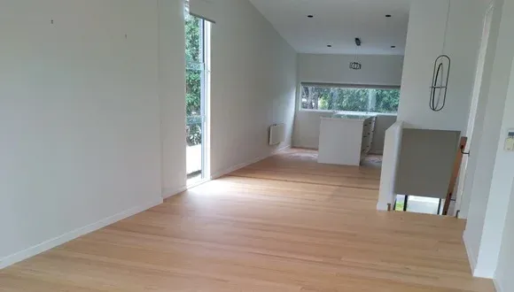 Empty living room with a wooden floor and white walls